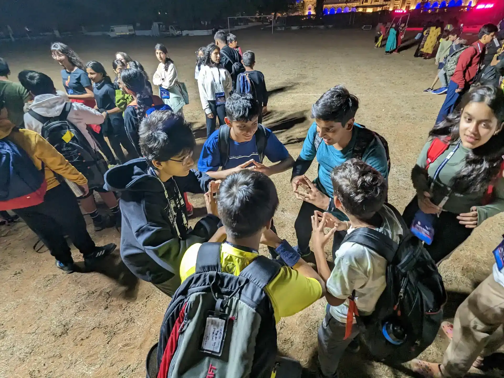 Students doing a team-building hand-stack exercise during a Cliff-Inn night camp